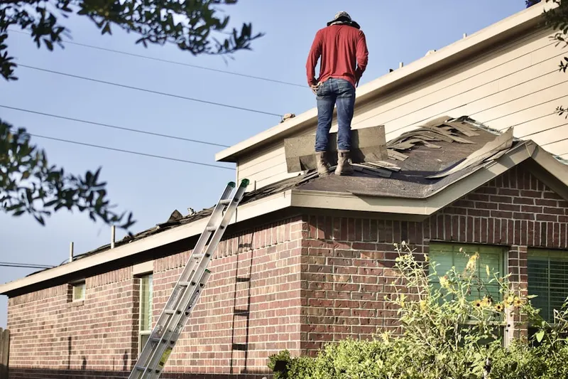 Professional roofer working on a residential roof in Greenwich